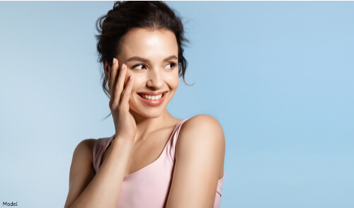 Woman touching her smooth skin on her face