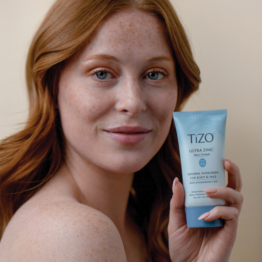 Woman holding TIZO sunscreen