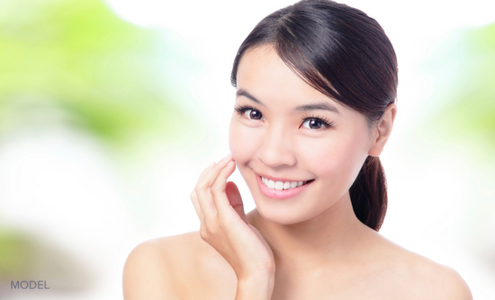 Woman smiling with hand touching face (MODEL)
